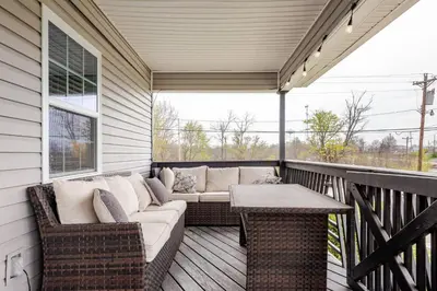 a screened in porch with a couch and a table at 5BR/3BA*Game Room*FirePit*Theater*3 mins to ARK! in Williamstown