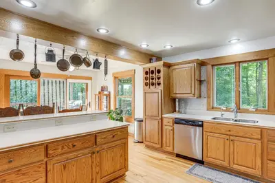 a kitchen with wooden cabinets and white countertops at Fish, Unplug and Unwind! Countryside Plymouth Home