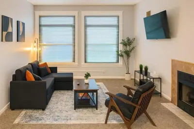 a living room with a couch and a fireplace at Bright Urban Retreat-Steps to CSU & Theater Dstrct in Cleveland