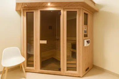 a wooden cabinet in a room with a white chair at Bright Urban Retreat-Steps to CSU & Theater Dstrct in Cleveland