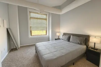 a bedroom with a large bed and a window at Bright Urban Retreat-Steps to CSU & Theater Dstrct in Cleveland