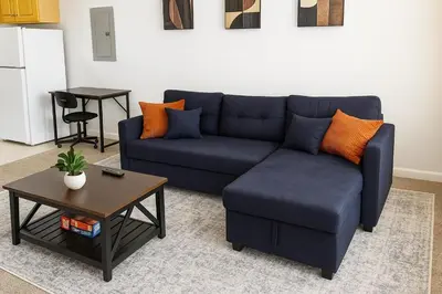 a living room with a blue couch and a table at Bright Urban Retreat-Steps to CSU & Theater Dstrct in Cleveland