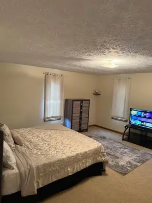 a bedroom with a bed and a flat screen tv at Great Price, Great Location in Canton