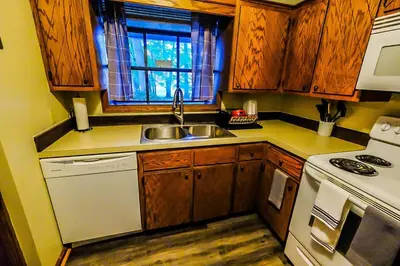 a kitchen with wooden cabinets and a sink and a stove at Great Price, Great Location in Canton