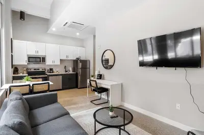 a living room with a couch and a kitchen at CozySuites at Textile in Cincinnati