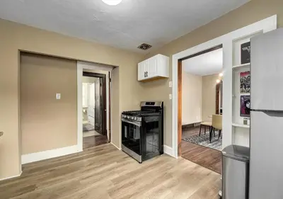 a living room with a stove and a kitchen at RocknRoll Crib 8 Min Cle Clinic Near Downtown in Cleveland