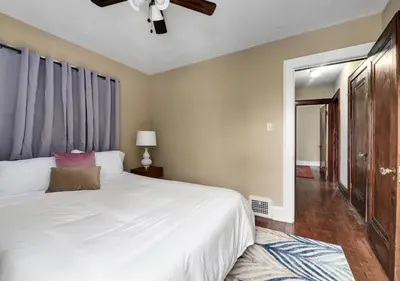 a bedroom with a white bed and a ceiling fan at RocknRoll Crib 8 Min Cle Clinic Near Downtown in Cleveland