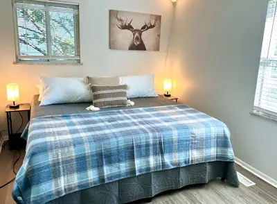 a bedroom with a bed with a plaid blanket at 4 Bed Ranch-Fire Pit-Pet & Kid Friendly-King Bed-Arcade in Columbus