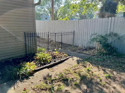 a garden with a fence in front of a house at 4 Bed Ranch-Fire Pit-Pet & Kid Friendly-King Bed-Arcade in Columbus