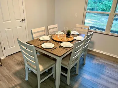 a dining room table with chairs and a wooden table and chairsktop at 4 Bed Ranch-Fire Pit-Pet & Kid Friendly-King Bed-Arcade in Columbus