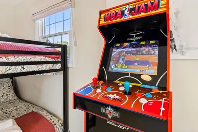 a video game machine in a room next to a bed at Ultimate Group Escape Heated Pool - 12 Guests in Parma