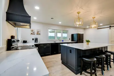 a large kitchen with black cabinets and white counter tops at 10 Mi to Red River Gorge Peaceful Rural Getaway! in Campton