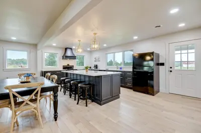 a kitchen with a large island with a black refrigerator at 10 Mi to Red River Gorge Peaceful Rural Getaway! in Campton