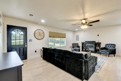 a living room with a couch and a clock on the wall at 10 Mi to Red River Gorge Peaceful Rural Getaway! in Campton