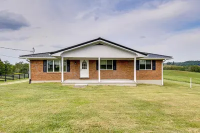 a small brick house with a grass yard at 10 Mi to Red River Gorge Peaceful Rural Getaway! in Campton