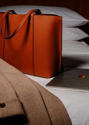 an orange bag sitting on top of a bed at The Amaya - 21 and older only in Fort Wayne