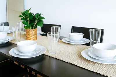 a table with plates and cups and a plant on it at Spacious Loft with Fireplace - near CSU, Playhouse, Progressive field, R&R Hall of Fame with Gym & Sauna and Sleeps 12 in Cleveland
