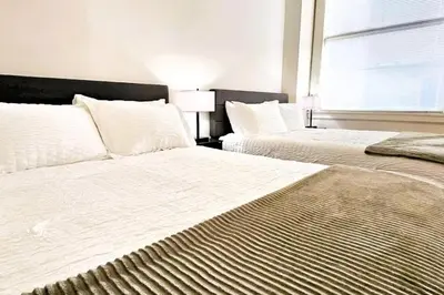 a bedroom with two beds and a window at Spacious Loft with Fireplace - near CSU, Playhouse, Progressive field, R&R Hall of Fame with Gym & Sauna and Sleeps 12 in Cleveland