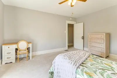 a bedroom with a bed and a desk and a ceiling fan at 1 Mi to Dtwn and Franciscan University Home with Yard in Steubenville