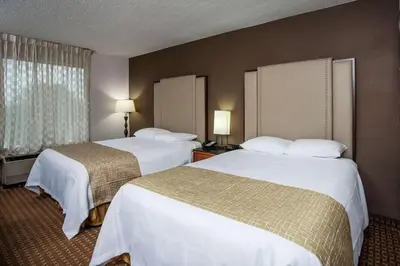 a hotel room with two beds and a window at Three Rivers Motel in Fort Wayne