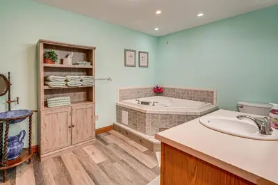 a bathroom with a tub and a sink at 1 Mi to Main St! Family Farmhouse in West Unity