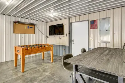 a room with a ping pong table and a television at 1 Mi to Main St! Family Farmhouse in West Unity