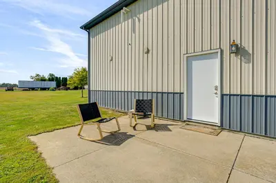 two chairs sitting outside of a building with a door at 1 Mi to Main St! Family Farmhouse in West Unity