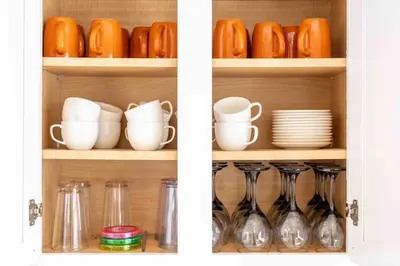 two views of a cupboard with dishes and wine glasses at Movie Theater-Game Room-Parking-Heart Of Cleveland in Cleveland