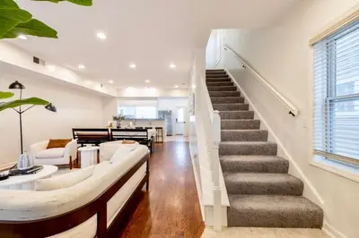 a living room with a couch and a stairway at Movie Theater-Game Room-Parking-Heart Of Cleveland in Cleveland