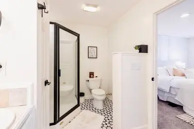 a bathroom with a toilet and a bed and a mirror at Movie Theater-Game Room-Parking-Heart Of Cleveland in Cleveland
