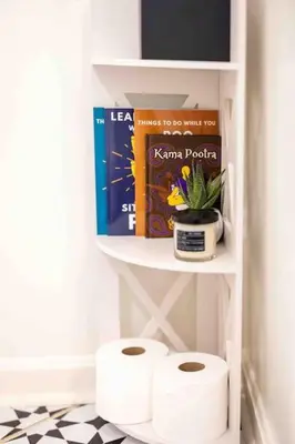 a shelf with two rolls of toilet paper and books at Movie Theater-Game Room-Parking-Heart Of Cleveland in Cleveland