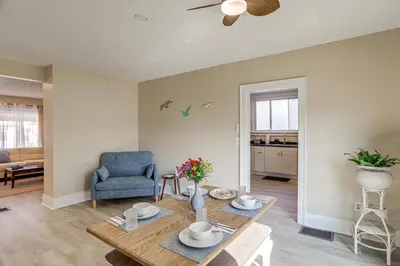 a living room with a table and a blue chair at 1 Mi to Cedar Point Family Getaway with Porch! in Sandusky