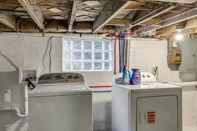 a kitchen with two washing machines and a window at 1 Mi to Cedar Point Family Getaway with Porch! in Sandusky