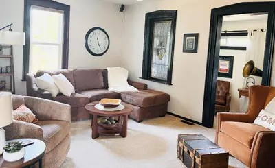 a living room with a couch and a table at Luxurious 1875 centrally located Canton Akron home, expansive primary & sunset view in Uniontown