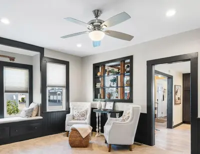 a living room with a ceiling fan and chairs at Luxurious 1875 centrally located Canton Akron home, expansive primary & sunset view in Uniontown