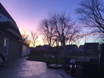 a sunset in a yard with trees and a house at Luxurious 1875 centrally located Canton Akron home, expansive primary & sunset view in Uniontown