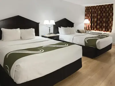two beds in a hotel room with two at 1734 West Hotel in Fort Wayne