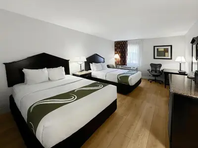 a hotel room with two beds and a desk at 1734 West Hotel in Fort Wayne