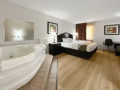a hotel room with a bed and a bath tub at 1734 West Hotel in Fort Wayne