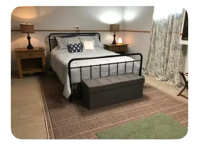 a bedroom with a bed and a ottoman in it at Shaker Heights Apartment near Cleveland Clinic in Shaker Heights