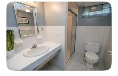 a white bathroom with a toilet and a sink at Shaker Heights Apartment near Cleveland Clinic in Shaker Heights