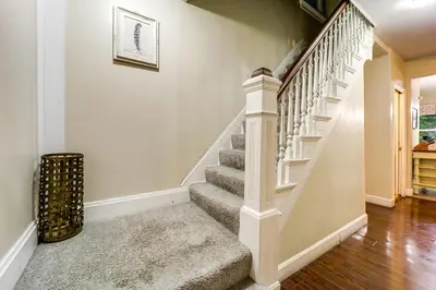 a staircase in a home with white walls and wood floors at Walk to University of Cincinnati Historic Home! in Cincinnati