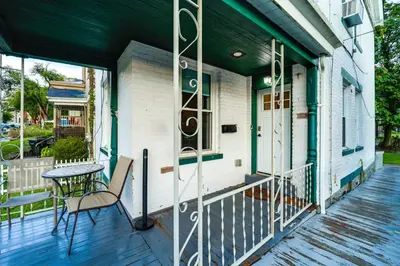 a porch of a house with a table and a chair at Walk to University of Cincinnati Historic Home! in Cincinnati