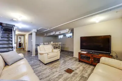 a living room with a flat screen tv and couches at Walk to University of Cincinnati Historic Home! in Cincinnati