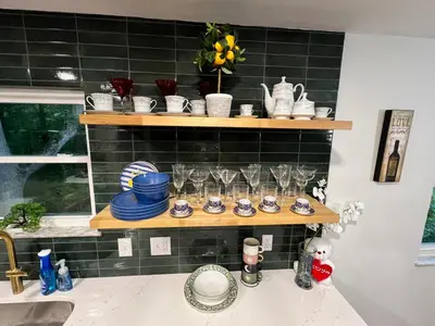 a shelf filled with glasses and dishes on top of a sink at Gorgeous Timberwood 3bedr 3bath with basement 4 beds in Sharonville