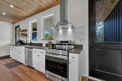 a kitchen with white cabinets and a stove top oven at Luxury Cabin in Hocking Hills The Buffalo in Logan
