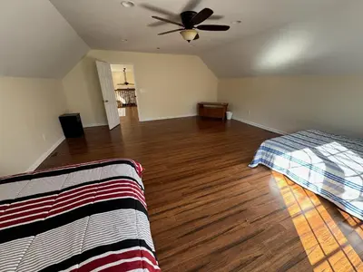 an empty room with a bed and a ceiling fan at Large Family Gathering Home on Kelleys Island in Kelleys Island
