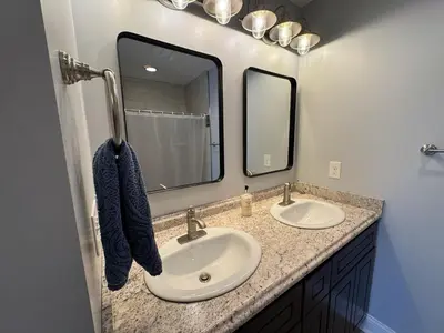 a bathroom with two sinks and a mirror at Large Family Gathering Home on Kelleys Island in Kelleys Island