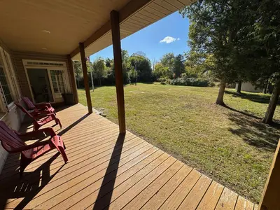 a porch of a house with two chairs on it at Large Family Gathering Home on Kelleys Island in Kelleys Island