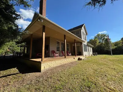 a porch of a house with red chairs on it at Large Family Gathering Home on Kelleys Island in Kelleys Island